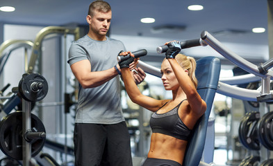 man and woman flexing muscles on gym machine