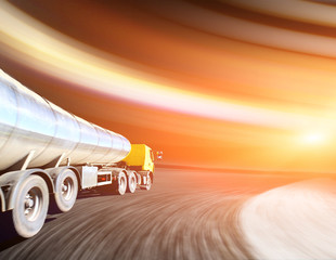 Canvas Print - Yellow truck on blurry asphalt road over cloudy sky