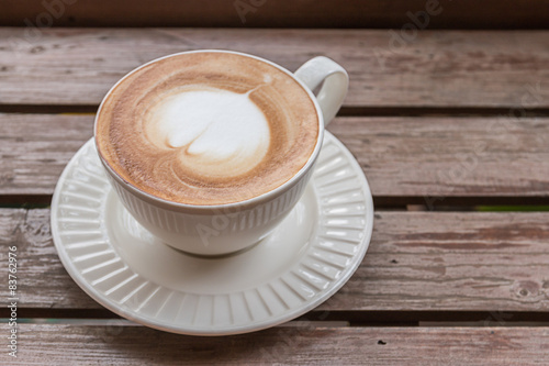 Tapeta ścienna na wymiar Heart shaped latte on a wooden floor.