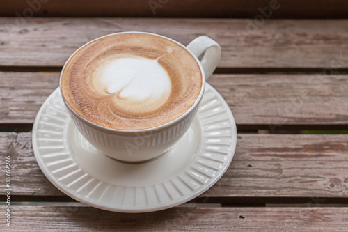 Obraz w ramie Heart shaped latte on a wooden floor.