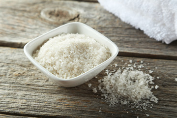 Sea salt in white bowl on grey wooden background