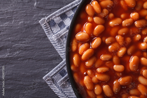 Fotomural beans in tomato on a plate close-up. horizontal top view