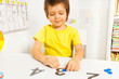 Smiling boy put coins on numbers learning count
