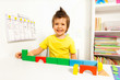 Laughing cute boy putting blocks in sequence 