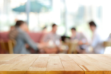 Wood table top with blurred people in cafe as background