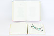 Open blank notebook with glasses and pencil on the top