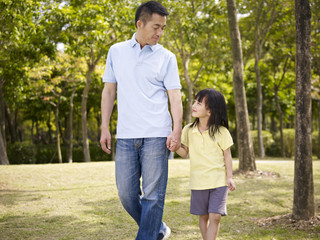 Wall Mural - asian father and daughter takes a walk in park