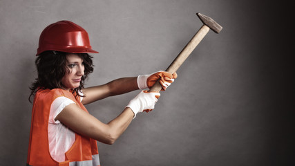 Wall Mural - Sexy girl in safety helmet holding hammer tool