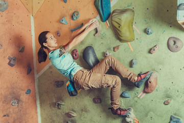 Poster - Sporty girl climbing on practice wall