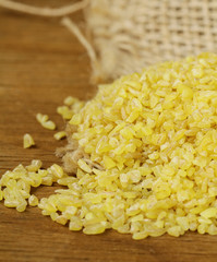 yellow natural grain bulgur on a wooden table 