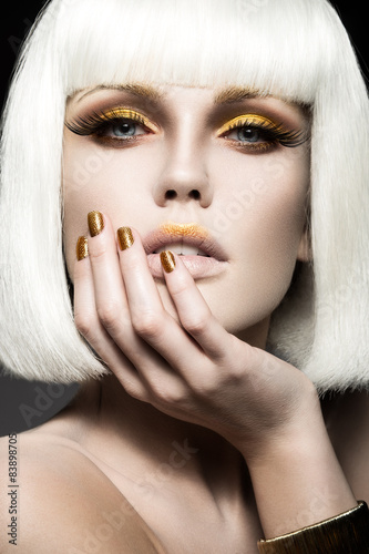 Nowoczesny obraz na płótnie Beautiful girl in a white wig, with gold makeup and nails