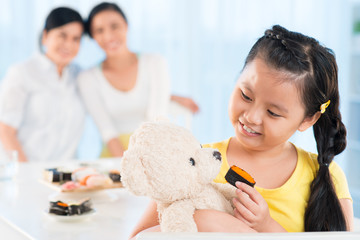 Wall Mural - Feeding her teddy bear