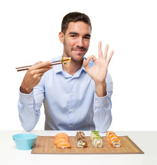 Young man eating sushi