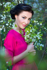 Wall Mural - beautiful brunette woman in pink dress in blooming cherry tree g