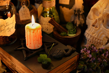 Magic still life with burning candle and four leaf clover