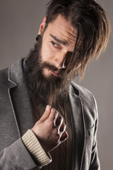 young man with a long beard and tatoos posing in the studio