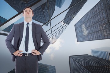 Poster - Composite image of serious businessman with hands on hips