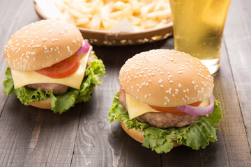 bbq hamburger with french fries and beer on the wooden backgroun