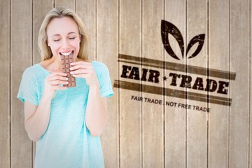 Poster - Composite image of happy blonde eating bar of chocolate