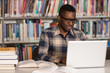 © Jale Ibrak - Happy African Male Student With Laptop In Library