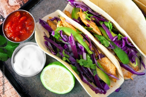 Fish tacos with red cabbage, avocado and lime on vintage tray Plakát
