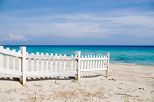 White Fence On The Beach With Blue Sea