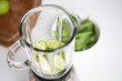 close up of blender jar and green vegetables
