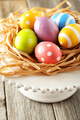  Easter eggs in nest on grey wooden background