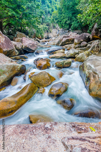 Naklejka na szybę Jungle waterfall with flowing water, large rocks