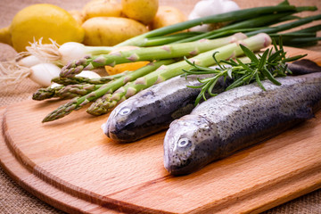 Two raw trout with green asparagus, lemon and rosemary