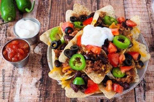 Fotografía Los nachos mexicanos con carga completa en el fondo de madera rústica