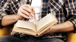 © Africa Studio - Young man reading book, close-up, on light background