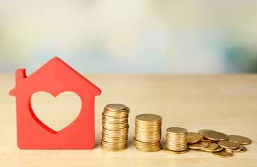 Canvas Print - Model of house with coins on bright background