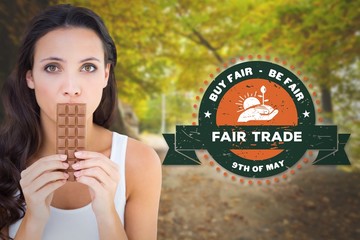 Poster - Composite image of pretty brunette eating bar of chocolate