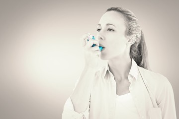 Poster - Composite image of pretty blonde using an asthma inhaler