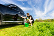 © kolotype - Man with Bucket Washing Black Car in Field