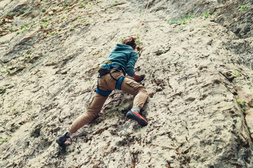 Poster - Active young woman climbing on rock