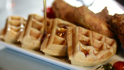 Wall Mural - Pouring syrup on a waffle, shallow depth of field
