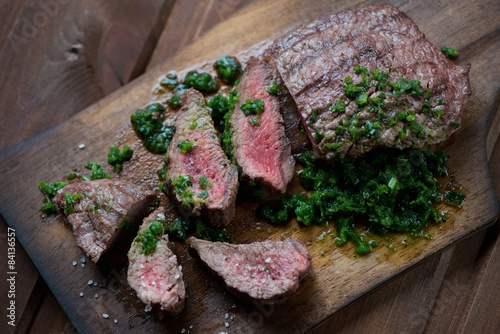 Sliced beef barbecue steak with chimichurri sauce, studio shot Poster