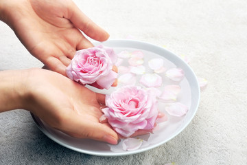 Canvas Print - Female hands with bowl of aroma spa water on table, closeup