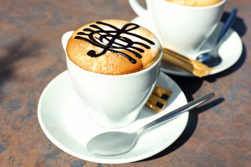 Cups of cappuccino with treble clef on foam on table in cafe