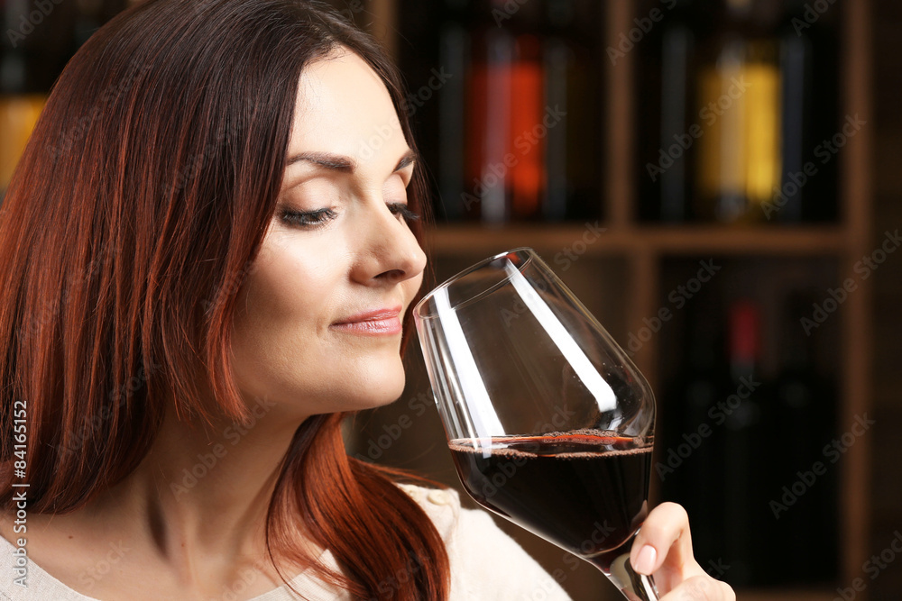 Young woman tasting wine in cellar