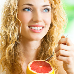 Poster - Young woman eating grapefruit