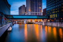 Buildings And Pedestrian Bridge Over The Milwaukee River At Nigh