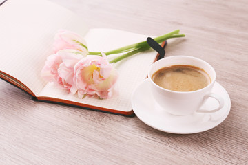 Poster - Beautiful tulips with book and cup of coffee on wooden background