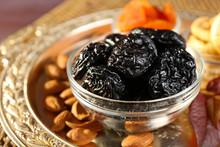 Prunes And Other Dried Fruits In Glass With Grape Leaves Saucers, Closeup