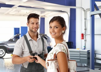 Canvas Print - Happy attractive young lady at auto repair shop