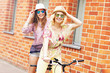 © Kalim - Two girl friends riding tandem bicycle
