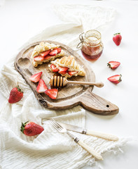 Wall Mural - Freshly baked croissants with strawberries, mascarpone and honey