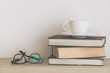 Coffee cup with book and eyeglasses